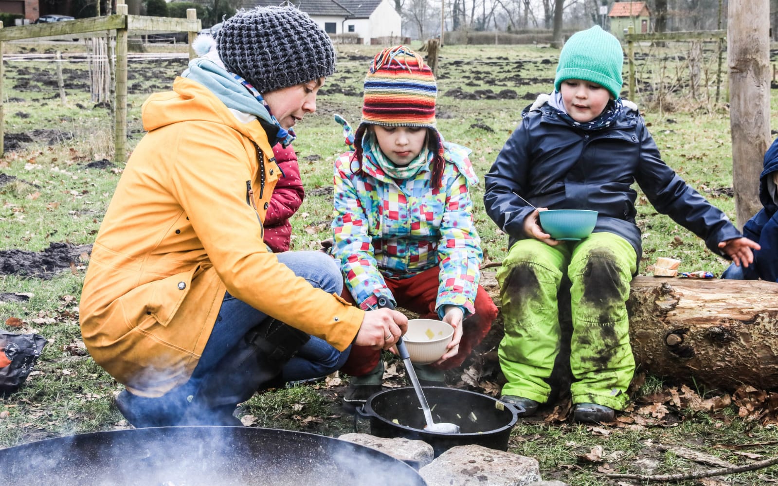 Kinder kochen gemeinsam am Lagerfeuer